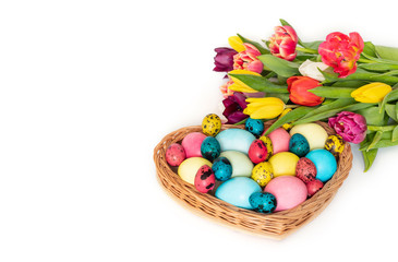 Fototapeta na wymiar Easter colorful eggs and a bouquet of spring tulip flowers on a white background. Horizontal orientation.