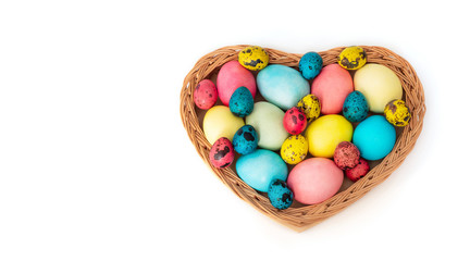Fototapeta na wymiar Easter colorful eggs in a basket with a heart shape on a white background.