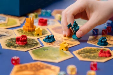 Bunte Brettspielfiguren und Würfel auf dem Feld, Hobby © Alena Gerasimova