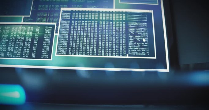 Different screen in a control center show computer code, binary data, data transfer. Slow panning shot.