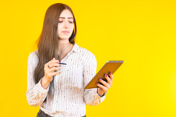 A woman holds a tablet in her hands. Female student with a gadget. Concept - a girl reads news on the Internet. The student receives a distance education. Getting education at home. Distance learning