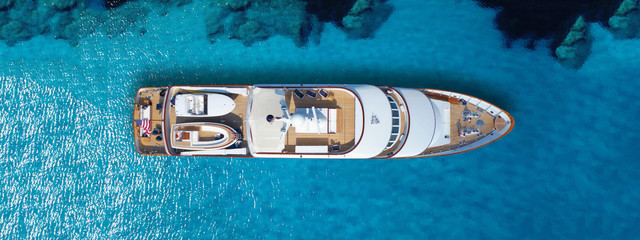 Aerial drone top down ultra wide photo of luxury yacht anchored in tropical exotic island turquoise...