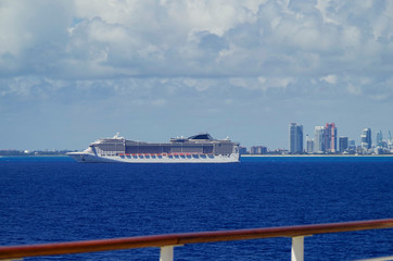 	 Huge modern MSC Cruises cruiseship or cruise ship liner MSC Divina at sea with skyline of Miami...