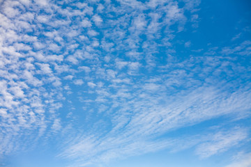Beautiful landscape with porous white clouds on blue sky.