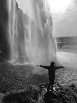 Silhouette &agrave; contrejour sous la cascade de Seljalandsfoss, Islande 