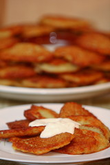 Homemade traditional potato pancakes, served with sour cream, top view.