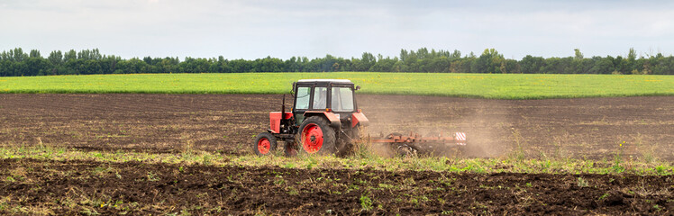 Tractor plowing field and tillage. Scenic agricultural land and farm. Agriculture. Preparing the...