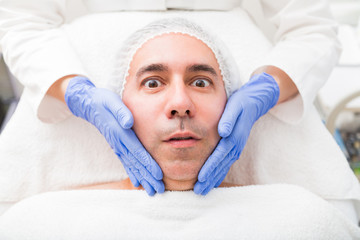 Fototapeta na wymiar Man having face massage in beauty salon close up