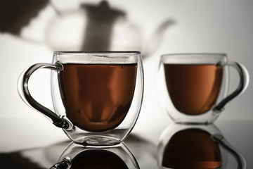 Two glass mugs with tea on a white background