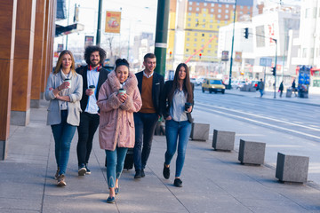 Obraz premium Group of diverse coworkers walking together, smiling and expressing a good vibe..