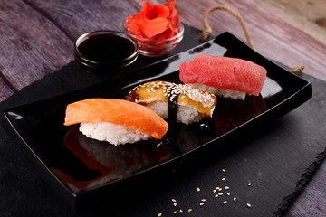 sushi with chopsticks on a black plate