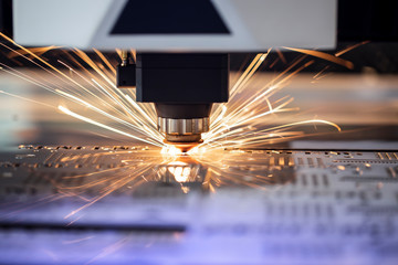 Automated programmed machine. Industrial laser machine cuts out parts in sheet steel. Heat. Sparks...