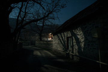 Full moon over quiet village at night. Beautiful night landscape of old town street with lights