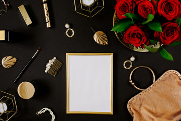 Golden blank frame with luxury golden accessories for women's beauty. Dating concept with red lipstick, roses, golden chain, earrings and handbag on black background. Elegant modern template for