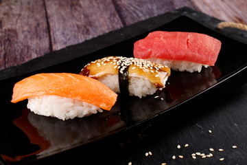 sushi with chopsticks on a black plate