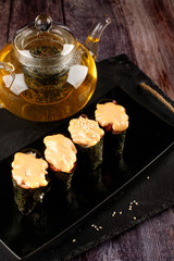 Baked sushi, rolls sprinkled with sesame seeds,