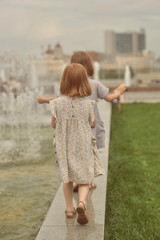 two little girls go near the fountain