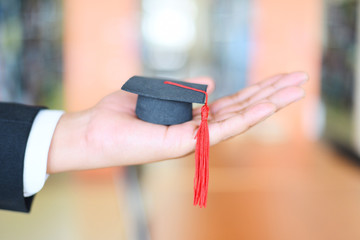 Graduation Education Business Study Concept - Business man or student with graduation cap on hand...