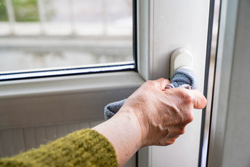 detail of woman cleaning the door and window at home. woman cleaning to protect against virus 