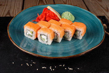 Rolls, wasabi, soy sauce, ginger on the table, avocado.