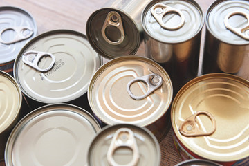 Various canned food in metal cans on wooden background , top view - canned goods non perishable food storage goods in kitchen home or for donations - 335802844