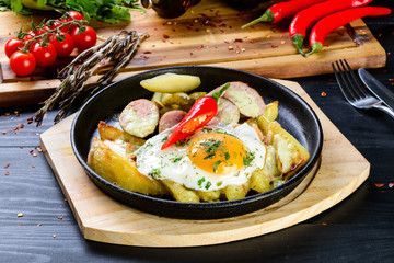 fried eggs and fried potatoes in a pan homemade food