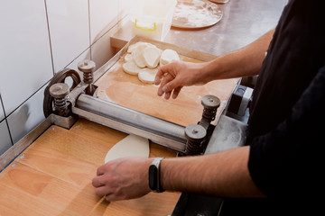 Obraz premium Chef preparing dough for pastry, dumplings, italian pasta or japanese wontons. 