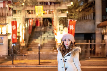 Japanese young woman standing behind Japanese traditional temple...