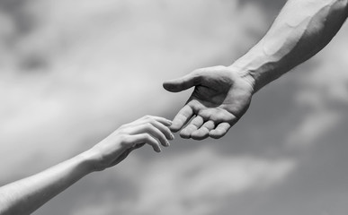 Giving a helping hand. Hands of man and woman on blue sky background. Lending a helping hand....
