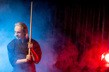 portrait of caucasian kendo fighter with bokuto, bamboo sword shinai. traditional japanese martial art of sword fighting