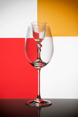 Two glass goblets on color gradient background