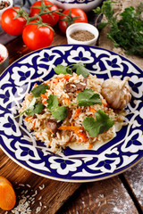 The concept of Oriental cuisine. Homemade Uzbek pilaf or lamb pilaf is served