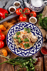 The concept of Oriental cuisine. Homemade Uzbek pilaf or lamb pilaf is served