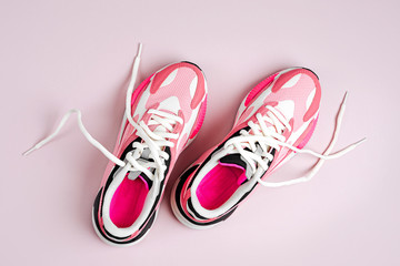 Fashion women's sneakers on a pink background. Female sport shoes.  Fitness concept. Top view, flat...