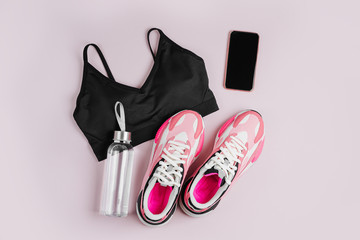 New sneakers and smartphone on a pink background. App for training indoors. Online Fitness program....