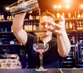Bartender is making cocktail at bar counter. Fresh cocktails. Barman at work.