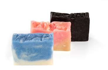 Three different handmade pieces of soap isolated on white background. Selective focus.