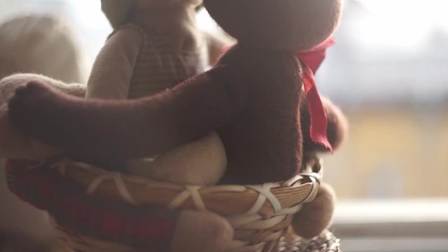 two toy bears on a windowsill in front of the open window and a ribbon is blown by the wind