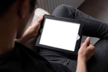 Teenage student is studying and surfing the internet using his tablet