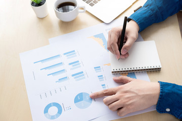 Businessman is pointing his finger on the business chart reports while auditing and inspecting the...