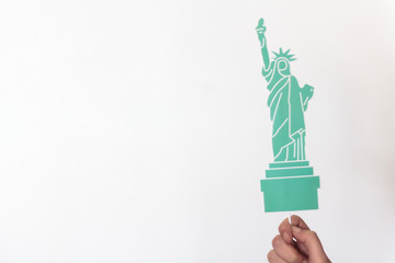 Woman hand holding statue of Liberty props with copy space