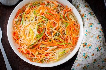 Funchose salad with fresh cucumbers and Korean carrots, selective focus, top view