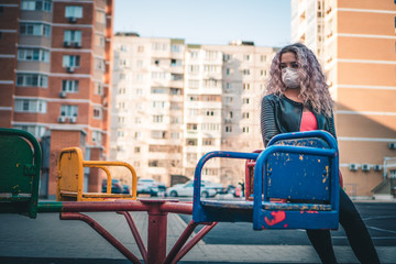 girl in protective medical mask on the playground