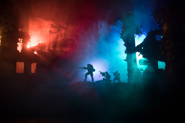 Army sniper with large caliber rifle standing in the fire and smoke. Backlit silhouette, toned image