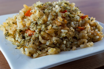 Rice with meat, vegetables and mushrooms on plate
