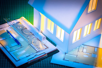 Fototapeta premium Architectural Bureau. Construction drawings. Layout of the house. Preparation of the layout of the house. Miniature mock up house. Work in an architectural bureau. Development of drawings.