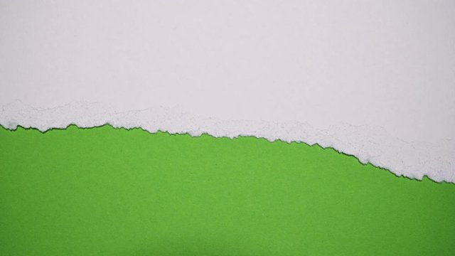 Tearing white paper horizontal revealing a green screen