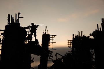 Army sniper with large caliber rifle standing in the fire and smoke. War Concept. Battle scene on...