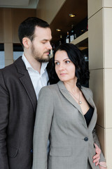 Fashionable adult couple. Man and woman in brown suits. The couple gently embraces.