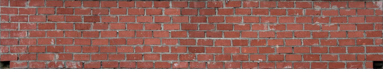 The brickwork of the old wall, uneven bricks and protruding mortar, sometimes destroyed.